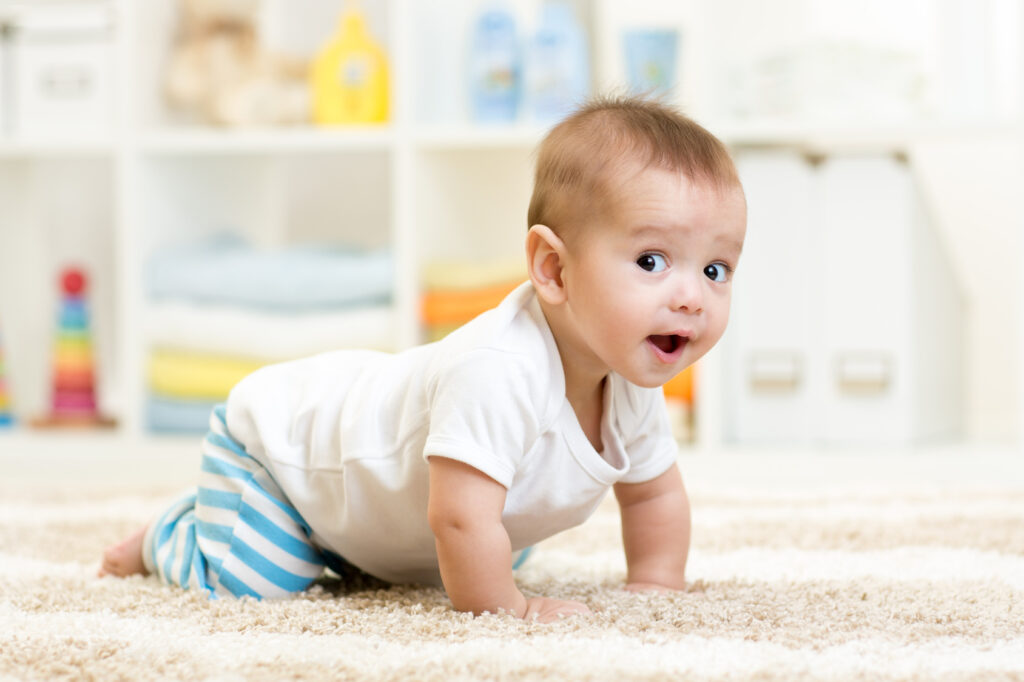 Krabbelndes Baby auf einem Teppich
